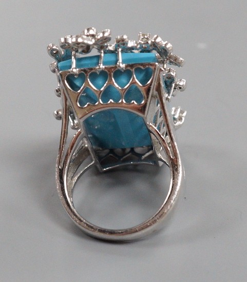 A large modern 14k white metal, turquoise and diamond chip set dress ring, the rectangular 'chequerboard' top cut turquoise weighing approx. 18.25ct, size M, gross weight 15 grams.